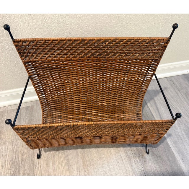 Bring timeless Mid-Century Modern style to your home with this vintage magazine rack featuring a sturdy black iron frame...
