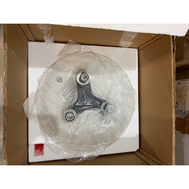 The Glaze large flush mount light fixture features a trio of frosted opal glass globes cocooned within a large ivory...