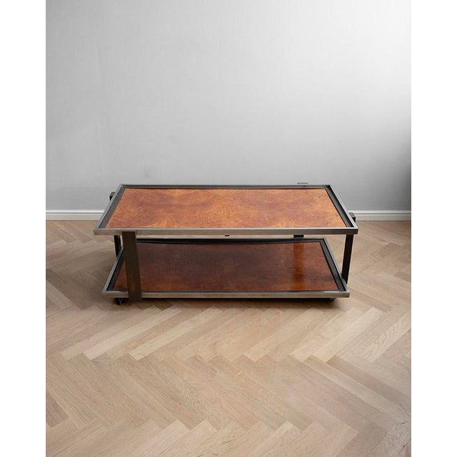 This Italian coffee table from the 1970s was made in Italy. It has a metal structure and two storage surfaces with a...