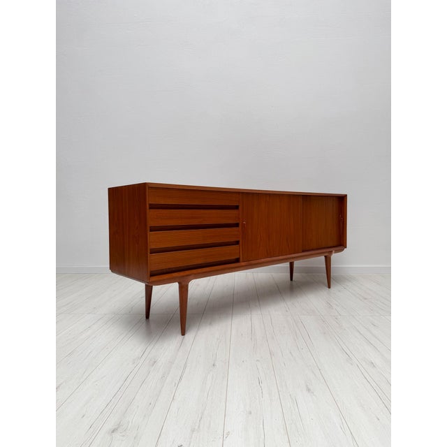 Elegant danish sideboard model 18 designed by gunni omann for omann jun during the 1960s. Crafted in teak, the piece...
