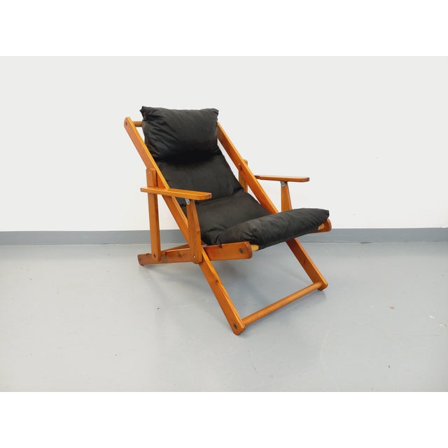 Vintage 1970s folding chaise lounge chair, made of pine wood with a quilted black faux leather seat cushion, in the...