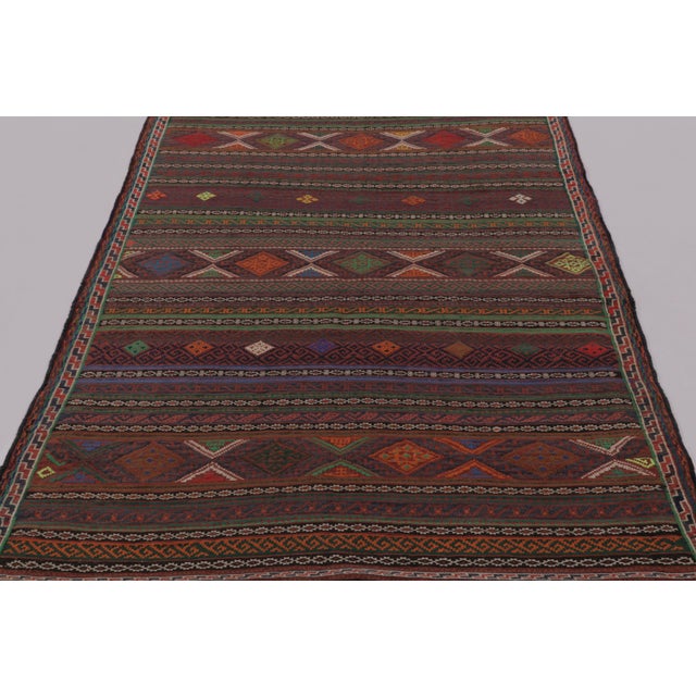 Made with handwoven wool circa 1950-1960, this 5x7 vintage Persian Kilim, originating from the Larkhabi region of...