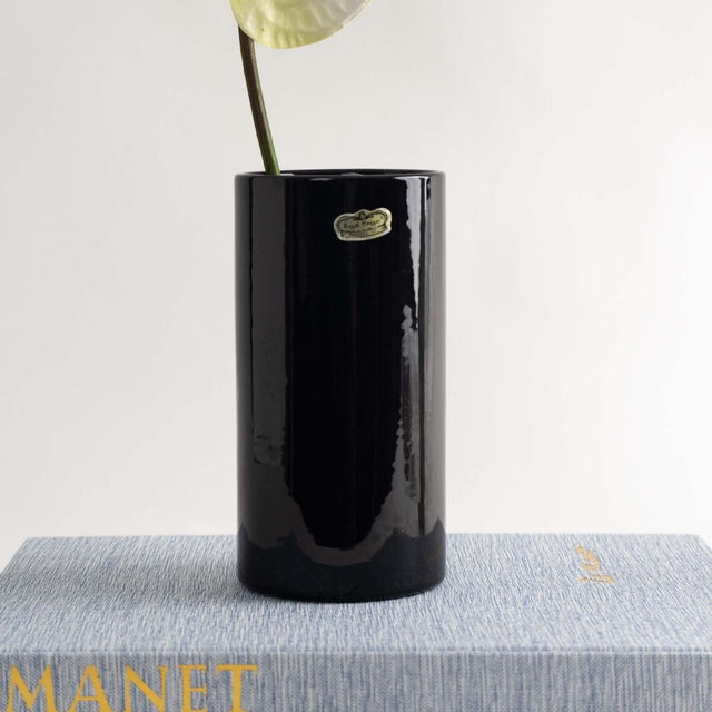 Classic black ceramic cylinder vase crafted by renowned maker Haeger. This timeless piece is ideal for showcasing flower...