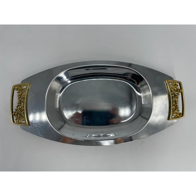 Shiny gold and silver colored Kromex serving tray on offer. Makers mark found on bottom of tray.