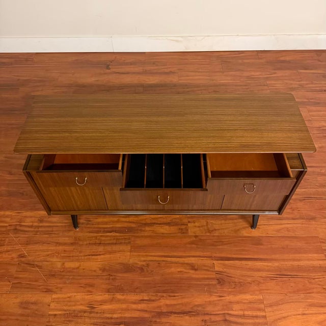 Vintage sideboard buffet with bi-fold doors that open to access three cabinet spaces, each with a height-adjustable shelf....