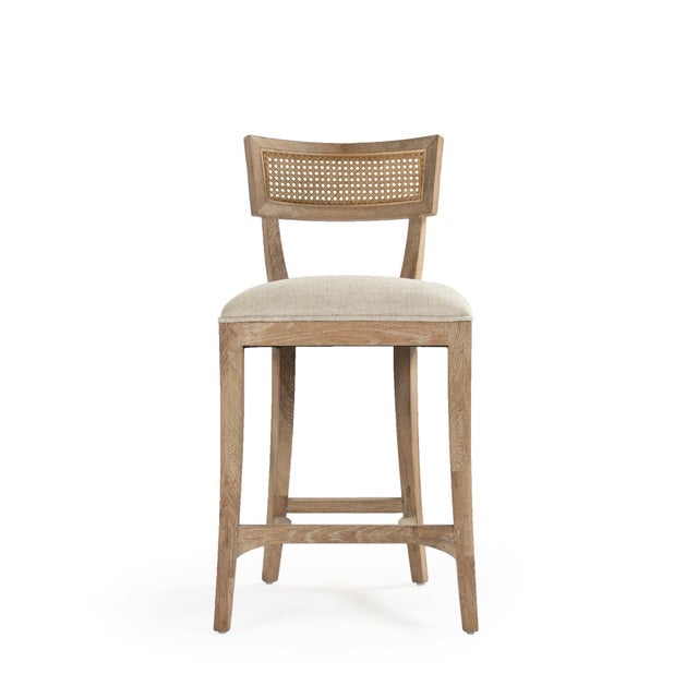 The Carvell Cane Back Counter Stool from Zentique pairs the collection's klismos-inspired silhouette with a woven cane...
