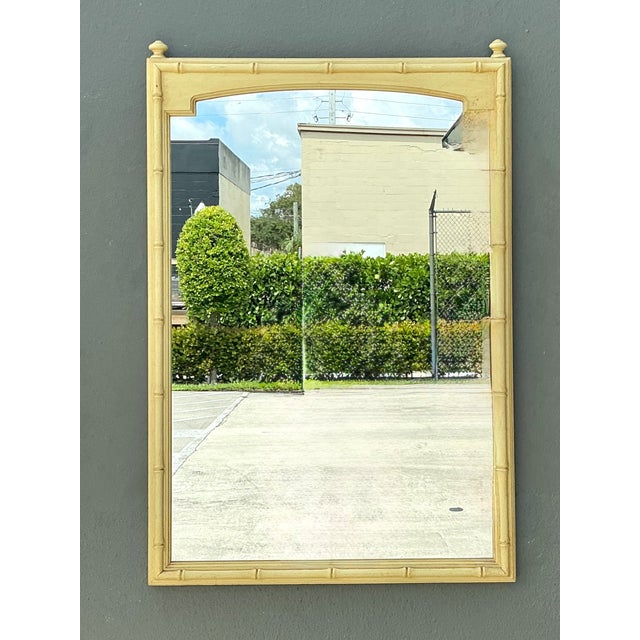 This vintage rectangular wall mirror captures the enduring appeal of mid-century design with its elegant faux bamboo wood...