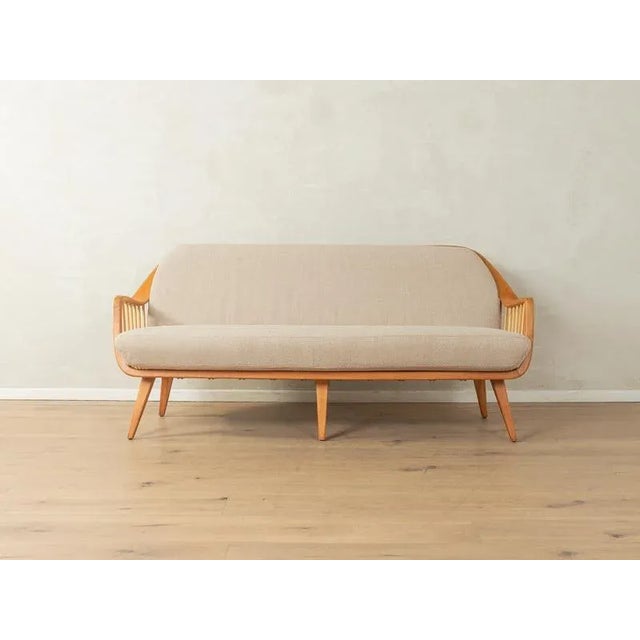 A unique sofa by Wilhelm Knoll from the 1950s. Solid cherry wood frame with decorative struts in the armrests and...