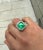 GRS certified 9.54 carat insignificant oil Colombian emerald and diamond mens ring. Featuring a round cut diamond halo and...