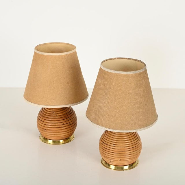 Gorgeous pair of mid-century table lamps in curved rattan and brass with cottonized hemp lampshades. These wonderful and...