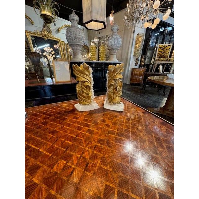 The "Pair of Antique Giltwood Fragments on Crystal Bases" is a set of sculpture pieces that feature antique giltwood...