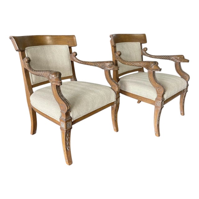 A striking pair of vintage carved wooden armchairs in a Regency / Empire Revival style, with beautifully sculpted dolphin-...
