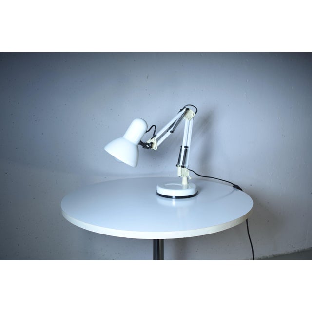 This lamp is a white desk lamp with an articulated arm, similar to an architect's design. This model is distinguished by...