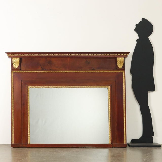 Fireplace mantelpiece from the early 19th century, Empire period. Made of walnut and veneered on the upper trabeation in...