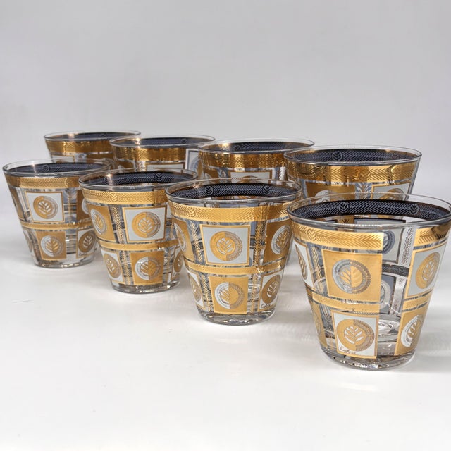 A striking Culver "Quadrille" barware set featuring the pattern's signature 22-karat gold decoration over smoky glass. The...