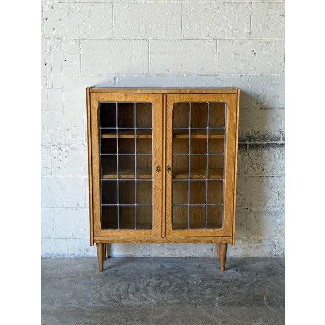 This attractive bookshelf features clean lines and an airy architectural profile. Twin glass doors showcase an elegant...
