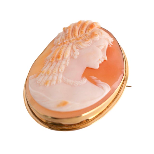 Late 19th Century This brooch is crafted in 18k yellow gold. The piece features a detailed cameo. Adorned with an...