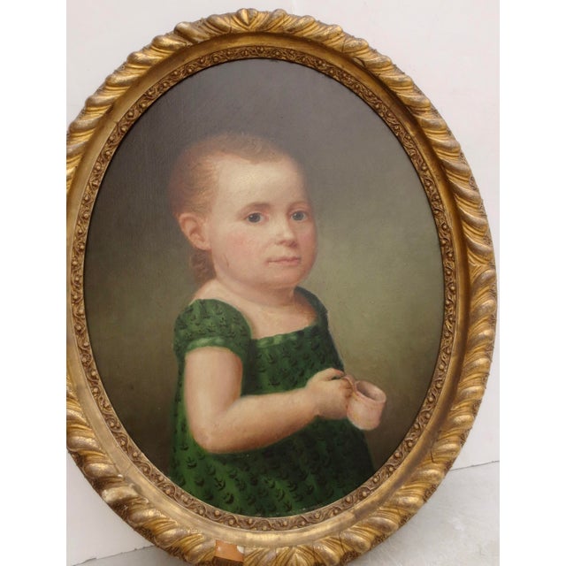 Early American Naive Portrait of a young child, likely a young boy due to the tradition of dressing and both sexes the...