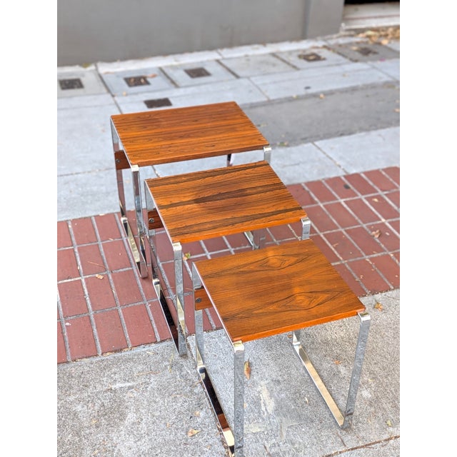 Set of three Norwegian rosewood and chrome nesting tables. The smallest table is stamped "Made in Norway"; the maker is...