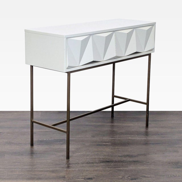 The modern drawer fronts are made from powder-coated brushed metal in a parchment finish and sit atop antique brass-...