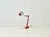 A striking 1970s desk lamp with classic industrial design and a movable spring mechanism. The bright red metal shade and...