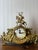 An elegant vintage brass mantel clock in the ornate Rococo Revival style, dating to the mid-to-late 20th century. Inspired...
