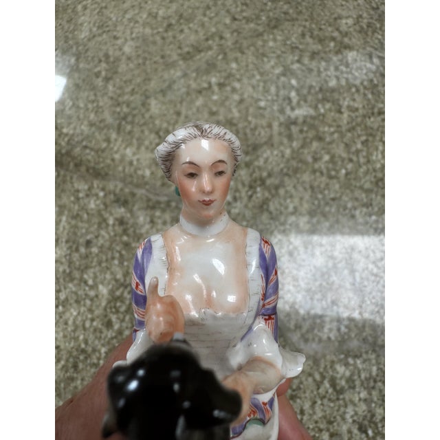 A delightful example of Danish Bing & Grondahl porcelain of a woman with a dog on her lap
