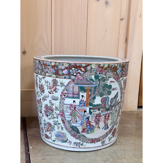 This is a beautifully decorated Chinese Famille Rose porcelain jardiniere, richly adorned with hand painted scenes of...