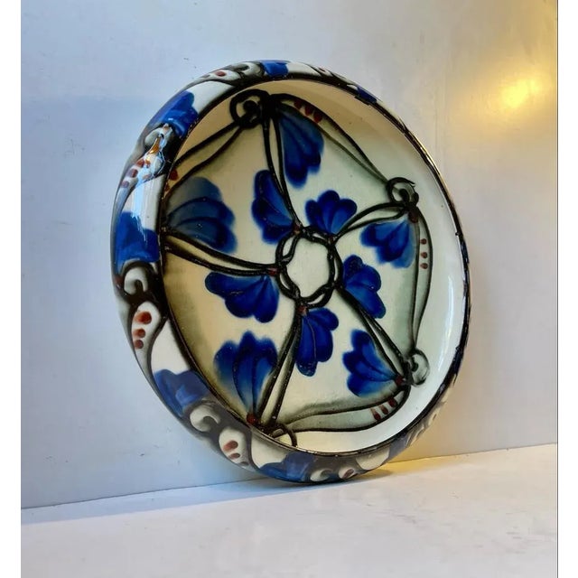 A danish jugendstil vase. The floral decorations on this vase was achieved by using slip trailed glaze through a cow horn...