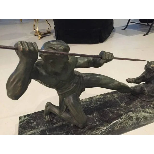 French Art Deco bronze painted metal on marble base of hunter and tiger. Great Deco details. Signed S. Melani.