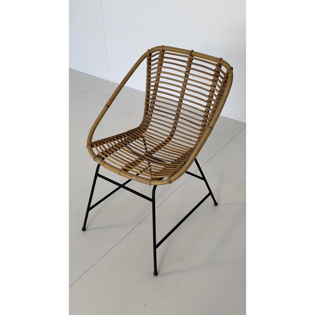 Woven rattan lounge chair, Italian design. Fits perfectly into a minimalist 1960s lounge setting. Matte black metal base.