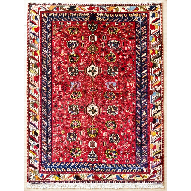 Antique hand-knotted rug from the Hamedan region of western Iran, featuring a vibrant red field filled with a dense array...