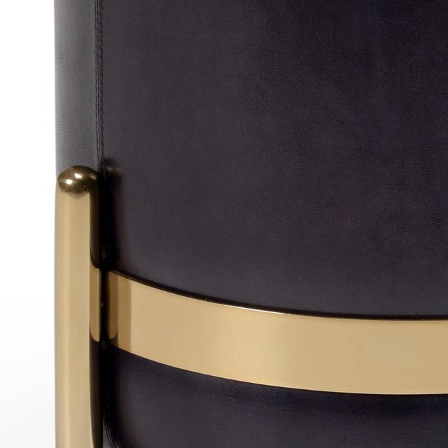 The bruce stool is wrapped in a deep midnight blue leather that is a mix of navy and purple and accented with brass plated...