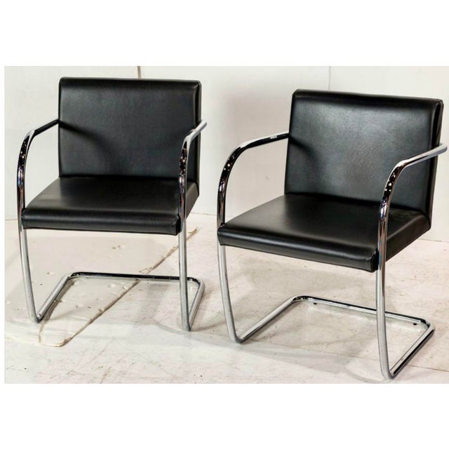 A pair of Italian Ludwig Mies van der Rohe style cantilevered chairs with soft black leather upholstered on tubular chrome...