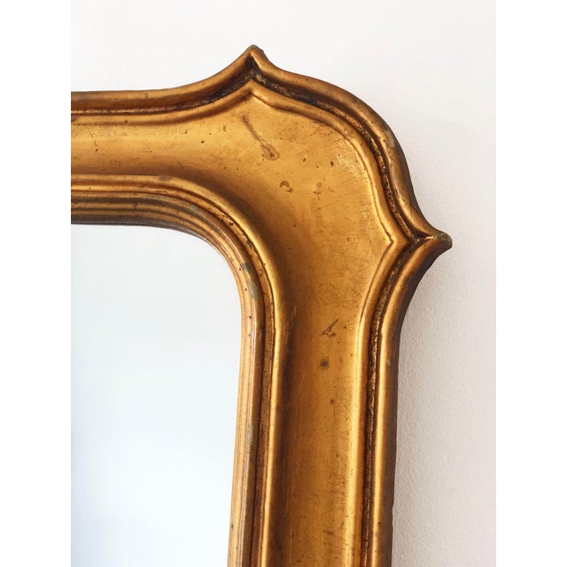Vintage Belgian gildwood mirror in Napoleon III style, with a wide wooden frame and subtle shoulders at the corners. The...