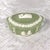 This is an oval Wedgwood jasperware covered trinket box in Celedon. The base is shaped with higher sides than the middle...