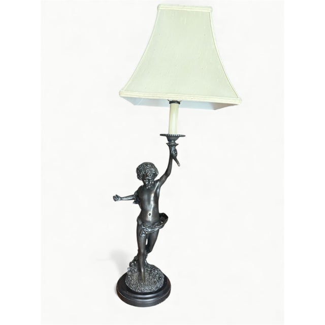 Beautiful bronze table lamp after sculptor Auguste Moreau (French, 1834-1917). The cherub stands with one arm raised and...