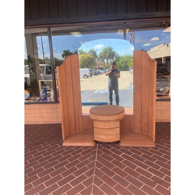 The structure is quite distinct, with two tall, vertical "wing" cabinets or shelves flanking a central circular base that...