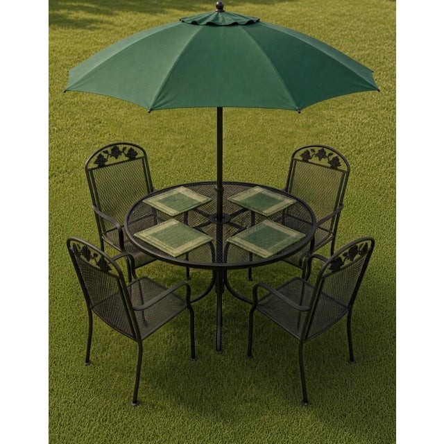Durable wrought iron patio set in black. This set has a round mesh-top table with an umbrella hole and matching armchairs....