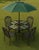 Durable wrought iron patio set in black. This set has a round mesh-top table with an umbrella hole and matching armchairs....