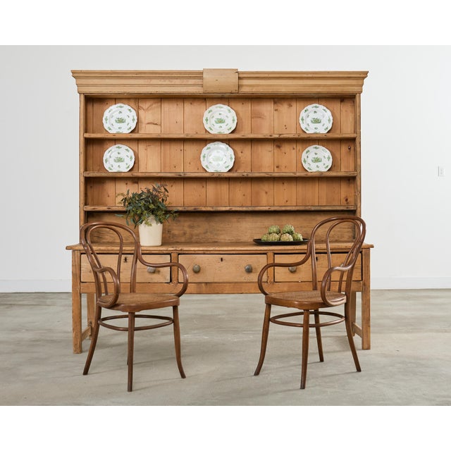 A handsome and functional 19th-century Country English provincial farmhouse pine kitchen dresser or cupboard featuring an...