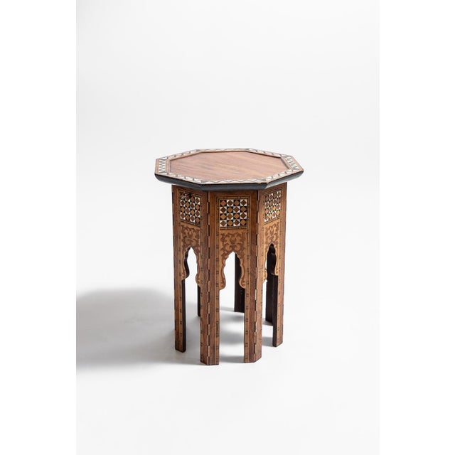 An octagonal Moorish table, inlaid in mother-of-pearl and ebony set in geometric patterns. The lid is hinged, concealing a...