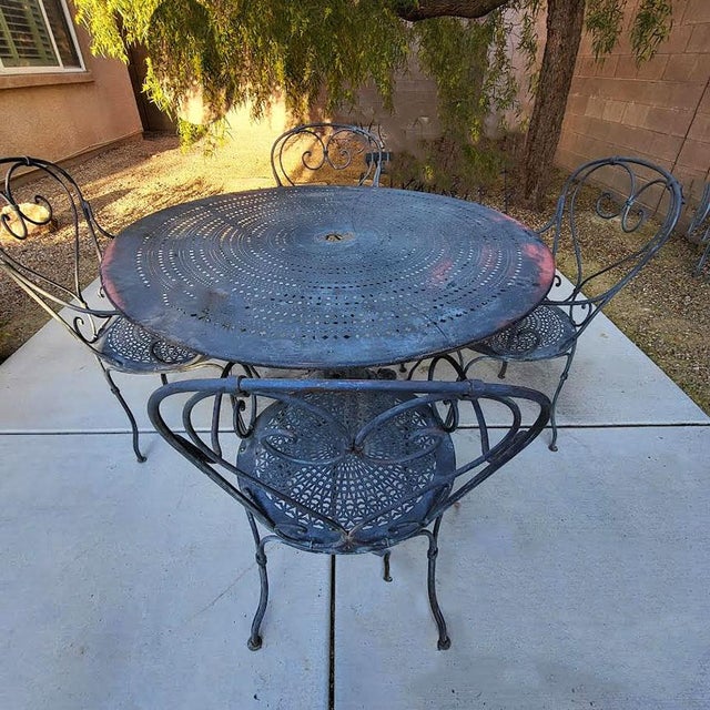 Vintage French bronze outdoor patio table & 4 arm chairs. Great patina. Measurements: Table Height 29" Table Diameter 47",...