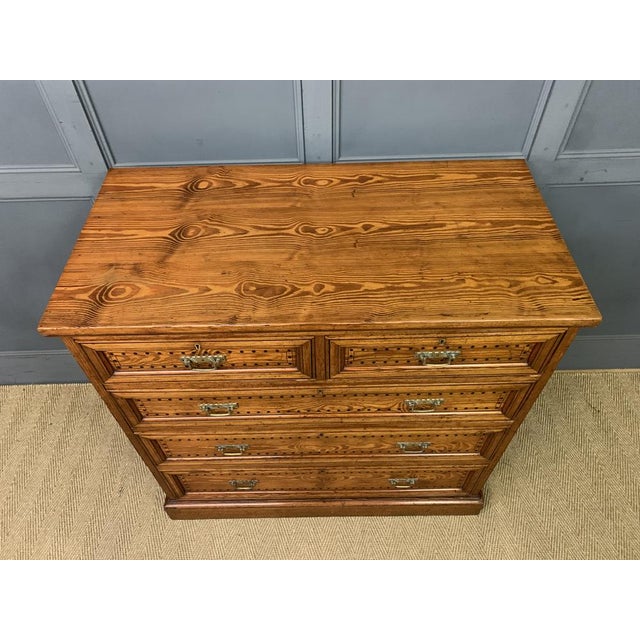 A charming 19th century pitch pine chest of drawers from the Aesthetic period. with an arrangement of 2 short over 3 long...
