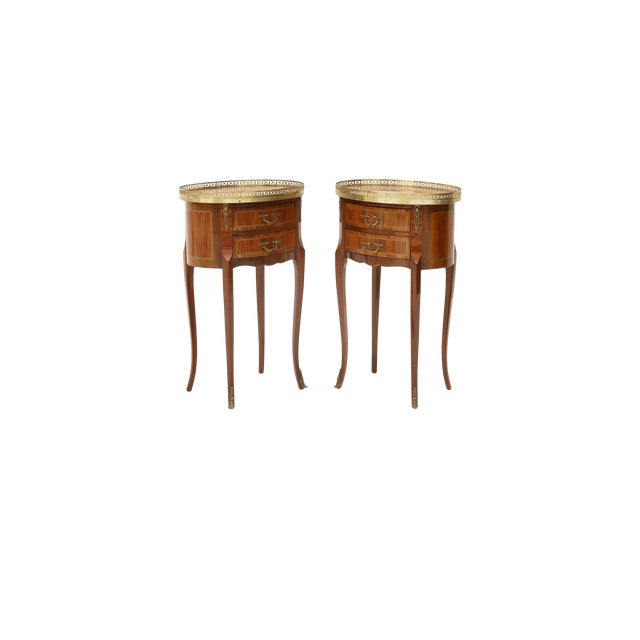 Elegant pair of French Louis XVI–style circular bedside or side tables featuring finely figured wood veneer arranged in...