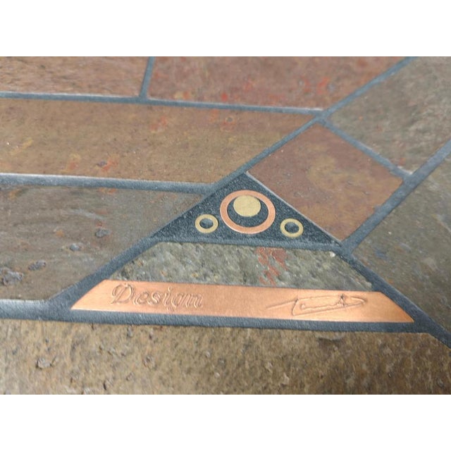 Brutalist slate and natural stone top coffee table with inlaid copper and brass. Black wooden base. The table is signed...