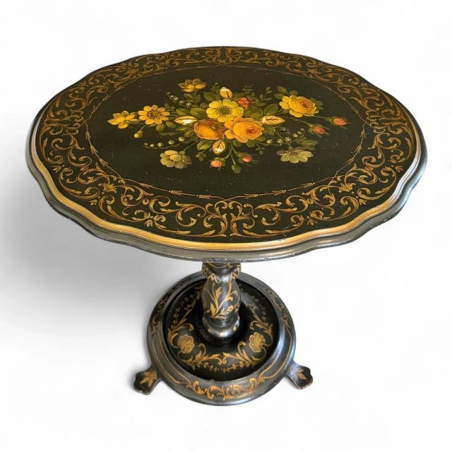 A late 19th century pine English Victorian tilt-top table; ebonized and featuring abalone inlays among elaborate paint...