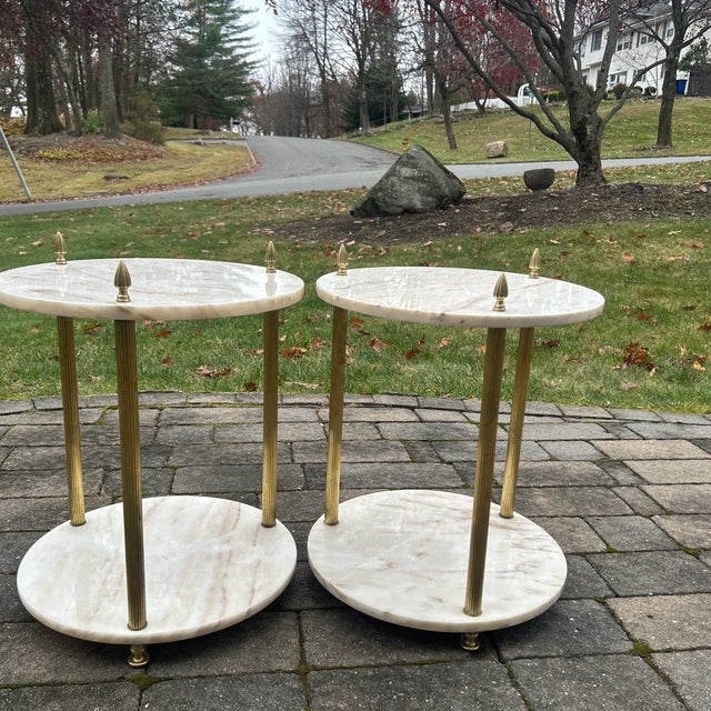 Pair 2 tier white marble top side tables. Brass finials, feet and fluted legs.