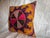 This vivid 1900s Suzani pillow showcases a star-shaped medallion surrounded by swirling motifs in golden yellow, plum,...
