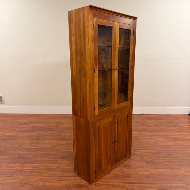 Vintage cherry display cabinet with hidden storage at the bottom and display space at the top behind beveled glass doors....